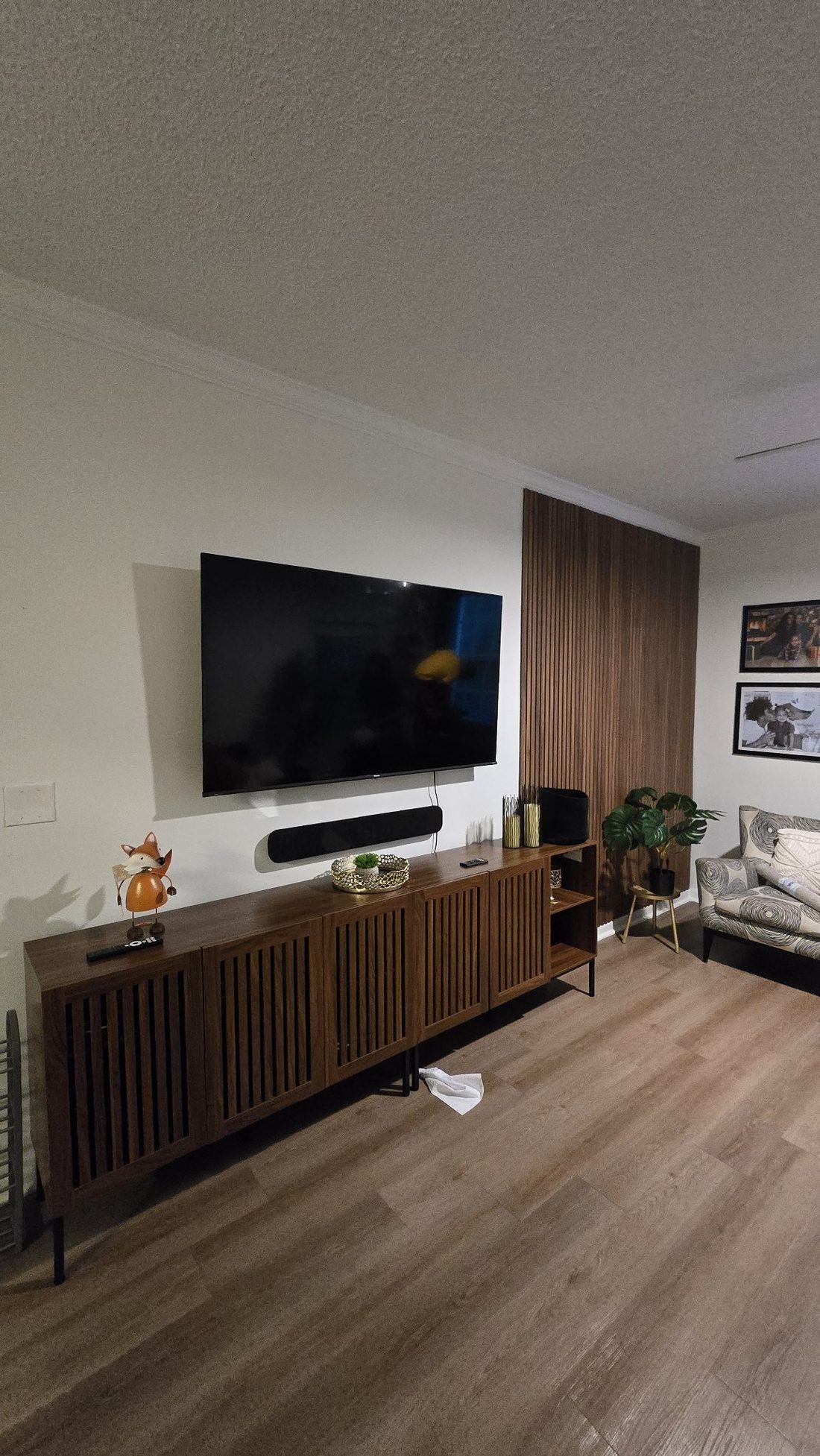 TV wall with slat panels and floating console — mounted and finished